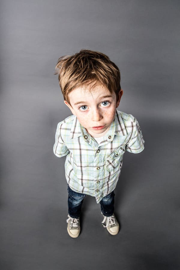 Overweldigde mooie jonge jongen die voor verrassing, hoge hoekmening staren stock afbeeldingen Overweldigde mooie jonge jongen die voor verrassing, hoge hoekmening staren stock afbeeldingen