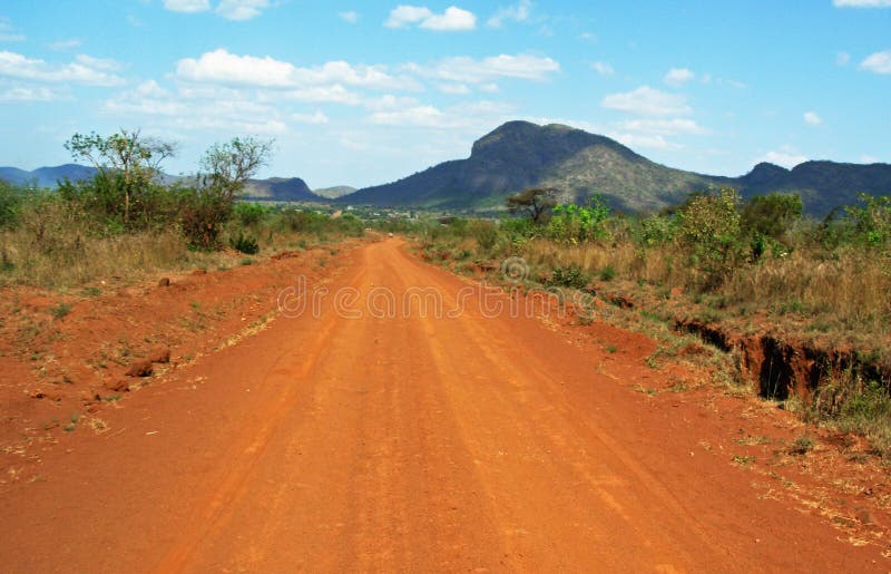 Overweldigend landschap die als achtergrond rode stoffige landweggen van Afrika drijven royalty-vrije stock afbeelding Overweldigend landschap die als achtergrond rode stoffige landweggen van Afrika drijven royalty-vrije stock afbeelding