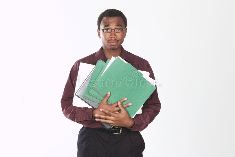 A man standing, holding folders and looking overwhelmed. A man standing, holding folders and looking overwhelmed.