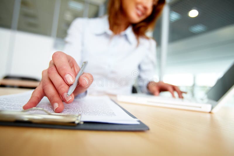 Human hand with pen over paper during work in office. Human hand with pen over paper during work in office