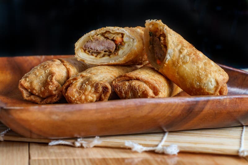 Crispy Chinese fried egg rolls with duck sauce on wooden table. Crispy Chinese fried egg rolls with duck sauce on wooden table