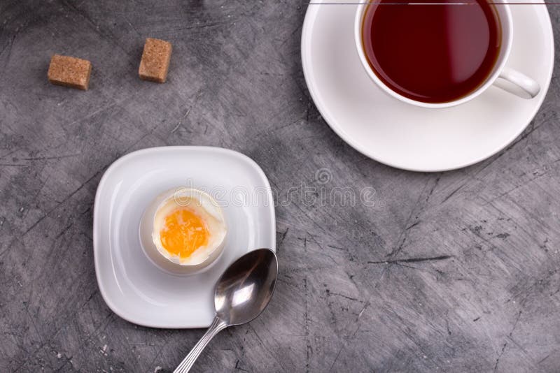 Healthy breakfast. Soft-boiled egg with tea on stone table. Healthy breakfast. Soft-boiled egg with tea on stone table