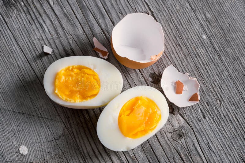 Sliced hard boiled eggs on wooden cutting board. Sliced hard boiled eggs on wooden cutting board