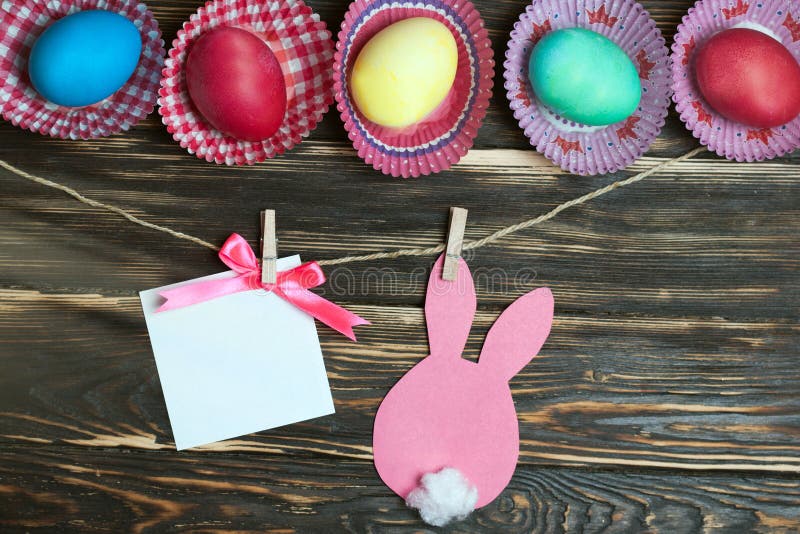Ovos da páscoa coloridos e coelhos de papel Cartão no fundo de madeira Mercadoria da Páscoa no estoque imagens de stock Ovos da páscoa coloridos e coelhos de papel Cartão no fundo de madeira Mercadoria da Páscoa no estoque imagens de stock