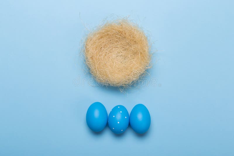 Ovos da páscoa coloridos no ninho no fundo azul com espaço foto de stock Ovos da páscoa coloridos no ninho no fundo azul com espaço foto de stock