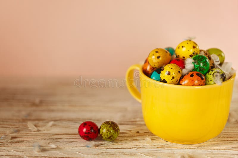 Ovos de codorniz coloridos na bacia amarela Conceito do feriado da mola da Páscoa imagem de stock Ovos de codorniz coloridos na bacia amarela Conceito do feriado da mola da Páscoa imagem de stock