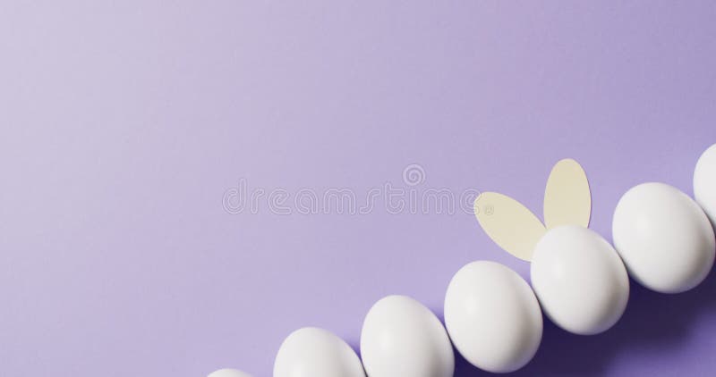 Ovos de páscoa brancos com sardas colocadas no feno amarelo tiro
