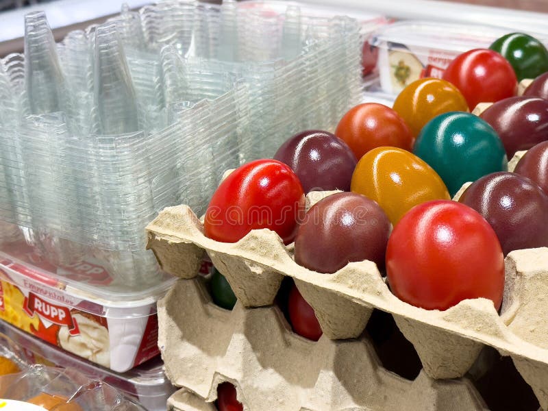 Ovos de páscoa coloridos em tabuleiro de cartão com queijo embalado e copos de plástico imagens de stock