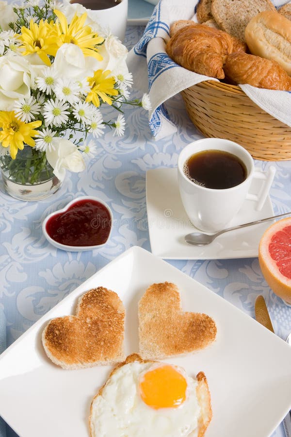 Valentine breakfast with heart shaped eggs and flowers. Valentine breakfast with heart shaped eggs and flowers