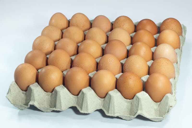 Eggs in carton box . close up brown fresh thirty 30 chicken eggs in packaging on white background. Eggs in carton box . close up brown fresh thirty 30 chicken eggs in packaging on white background