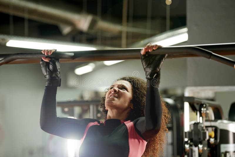 Owning Her Workout. a Young Woman Doing Pull Ups at the Gym. Stock