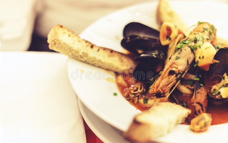 Owoce morza polewka z mussels, krewetki, ryba na białym talerzu z błękitnym ornamentem w restauracji Taormina, Sicily, Włochy obraz royalty free Owoce morza polewka z mussels, krewetki, ryba na białym talerzu z błękitnym ornamentem w restauracji Taormina, Sicily, Włochy obraz royalty free