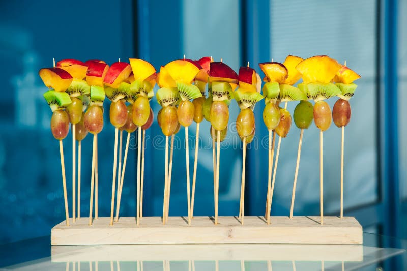 Owocowy jarski canape przy skewers z winogronami, kiwi i brzoskwinią przy czystym błękitnym tłem, catering przekąski usługa zdjęcie stock Owocowy jarski canape przy skewers z winogronami, kiwi i brzoskwinią przy czystym błękitnym tłem, catering przekąski usługa zdjęcie stock
