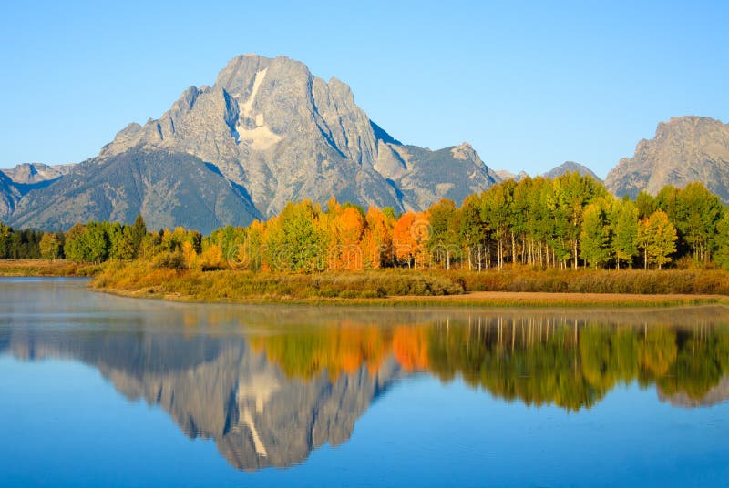 Landscape photograph of morning light shining on Mount Moran and fall trees reflecting in the Snake River at Oxbow Bend. Grand Teton National Park, Wyoming. Landscape photograph of morning light shining on Mount Moran and fall trees reflecting in the Snake River at Oxbow Bend. Grand Teton National Park, Wyoming