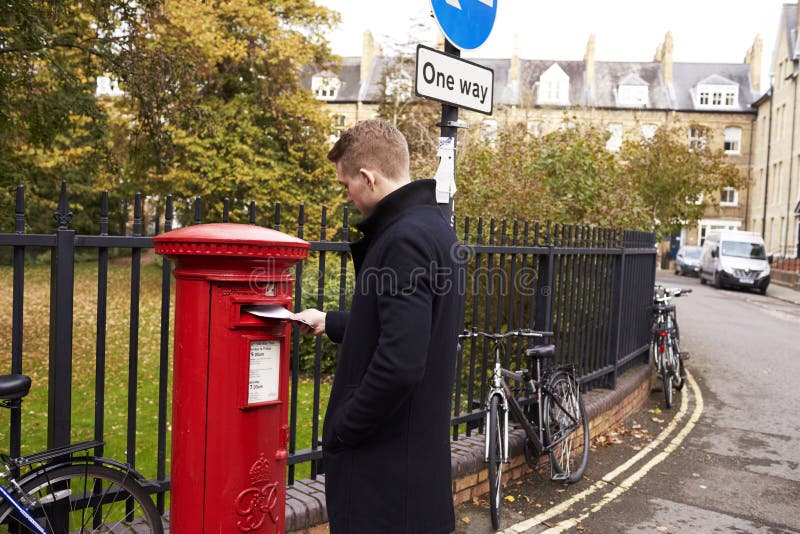 OXFORD/UK PAŹDZIERNIK 26 2016: Mężczyzna przeniesienia list W Royal Mail Postbox zdjęcie stock OXFORD/UK PAŹDZIERNIK 26 2016: Mężczyzna przeniesienia list W Royal Mail Postbox zdjęcie stock