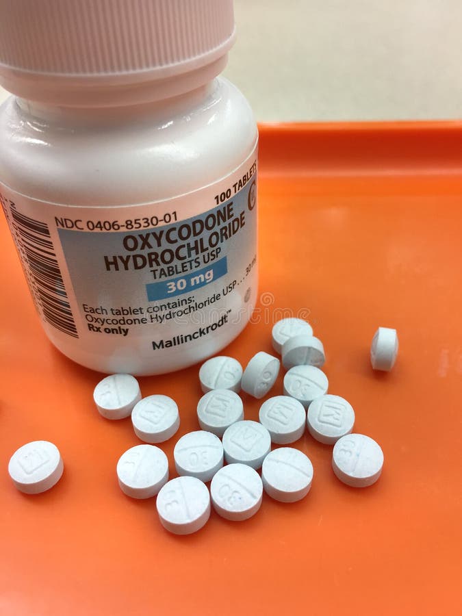 Oxycodone bottle on pharmacy tray with tablets poured out stock images Oxycodone bottle on pharmacy tray with tablets poured out stock images