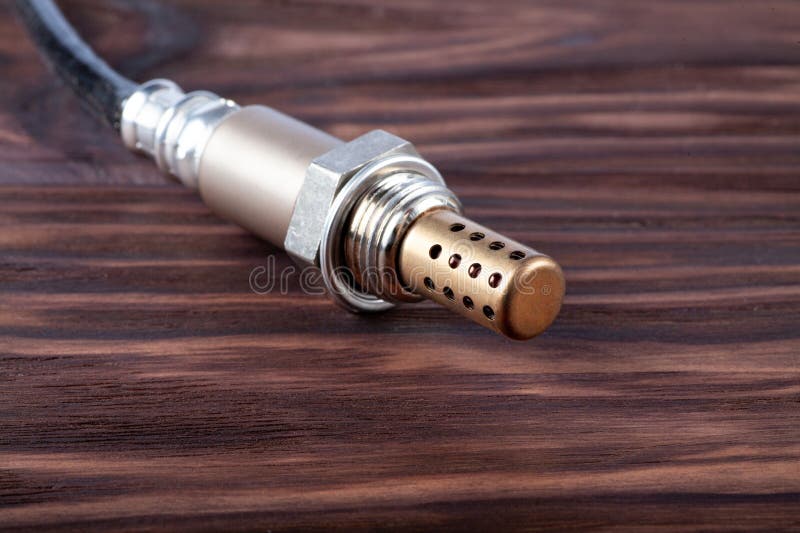 Oxygen sensor for gasoline and diesel engines on wooden table. lambda probe is reliable component to optimize your royalty free stock photo