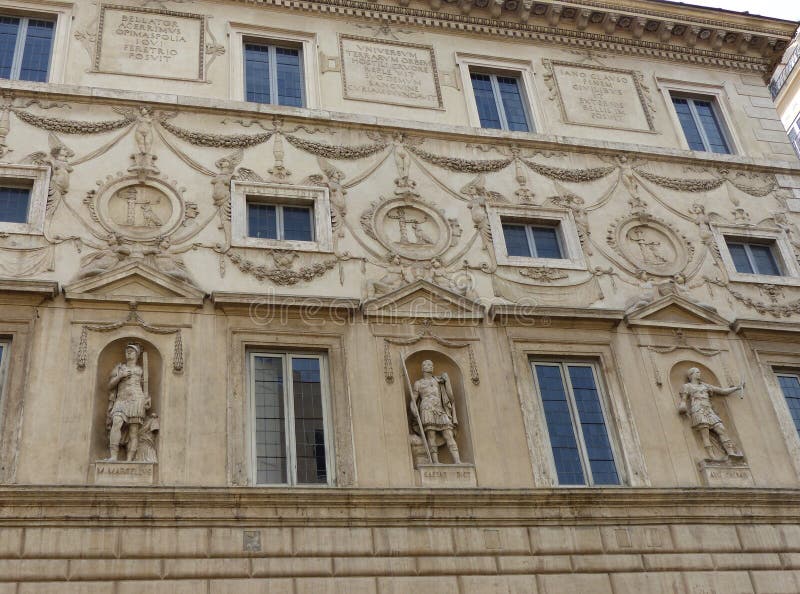 Ornate facade of statues at Palazzo Spada in Rome, Italy. Travel destination. Ancient windows of glass. Baroque style. Decorations of gardlands of flowers and fruit. Statues of roman kings on the side. Statues on niches and pedestals. White decorated palace. Seen from below. Latin writings. Engraving sculptures. Masterpiece of baroque and art. Ornate facade of statues at Palazzo Spada in Rome, Italy. Travel destination. Ancient windows of glass. Baroque style. Decorations of gardlands of flowers and fruit. Statues of roman kings on the side. Statues on niches and pedestals. White decorated palace. Seen from below. Latin writings. Engraving sculptures. Masterpiece of baroque and art.