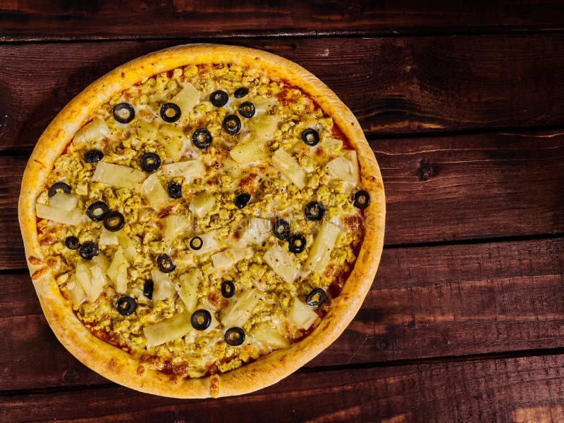Очень вкусная пицца с цыпленком и ананас на деревянном столе стоковое изображение Очень вкусная пицца с цыпленком и ананас на деревянном столе стоковое изображение