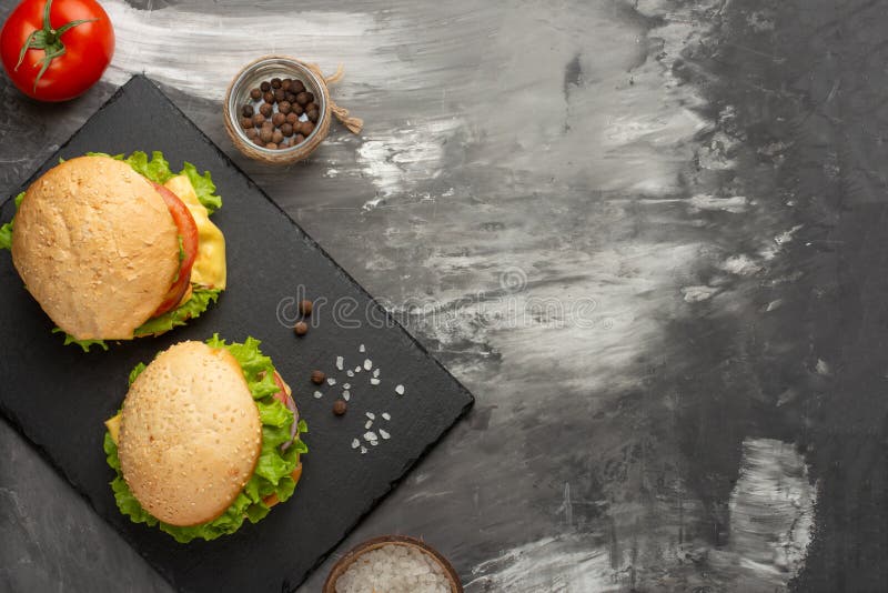 Очень вкусные домодельные бургеры, бургеры с говядиной, сыр, томаты, и салат Взгляд сверху с космосом экземпляра стоковое изображение rf Очень вкусные домодельные бургеры, бургеры с говядиной, сыр, томаты, и салат Взгляд сверху с космосом экземпляра стоковое изображение rf