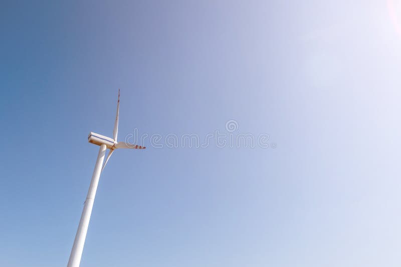 Lâminas rotativas de uma hélice de moinho de vento no fundo do céu azul  geração de energia eólica energia verde pura