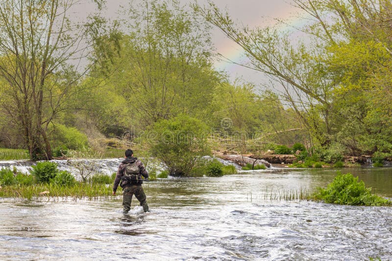 Pêcheur Sur Le Dos Avec Un Costume De Camouflage Et Des Bottes Hautes En  Caoutchouc Pataugeant La Rivière Avec Une Canne à Pêche D Image stock -  Image du loquet, ouvert: 218849471