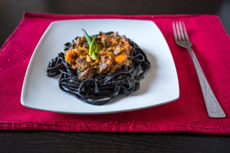 P?tes noires avec l'encre de seiches P?tes de semoule de bl? dur avec l'encre de calmar avec du boeuf et la sauce au poivre douce photo stock P?tes noires avec l'encre de seiches P?tes de semoule de bl? dur avec l'encre de calmar avec du boeuf et la sauce au poivre douce photo stock