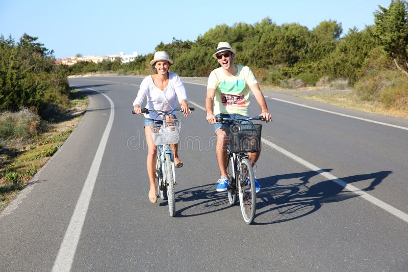 Paar berijdende fietsen op de geïsoleerde weg stock afbeelding Paar berijdende fietsen op de geïsoleerde weg stock afbeelding
