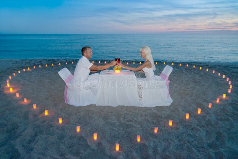 Paar bij strand romantisch diner met kaarsenhart stock afbeeldingen Paar bij strand romantisch diner met kaarsenhart stock afbeeldingen