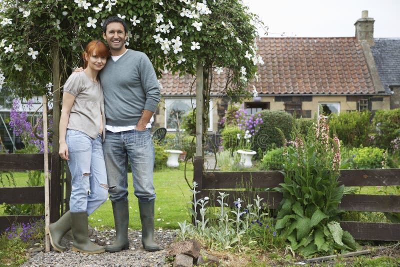 Full length portrait of a couple standing outside country house. Full length portrait of a couple standing outside country house