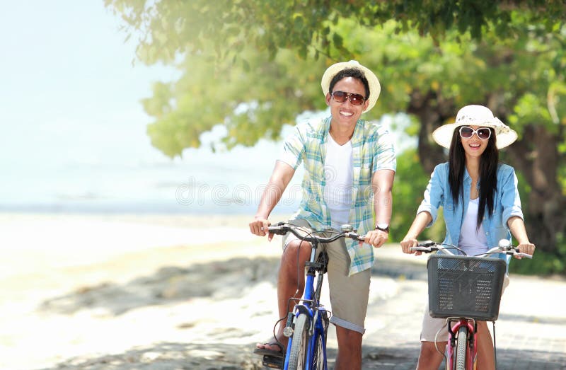Paar dat pret berijdende fiets heeft bij het strand stock foto's Paar dat pret berijdende fiets heeft bij het strand stock foto's
