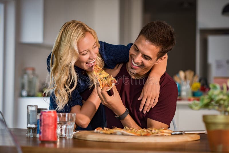 Paar die etend pizza genieten van