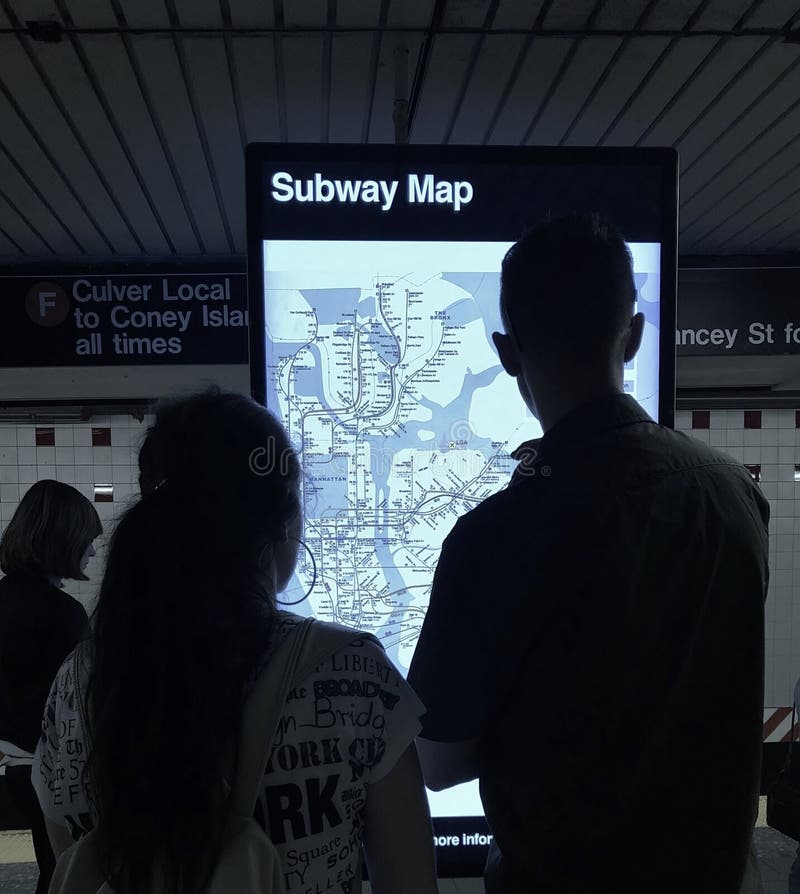 Couple Looking at Subway Information Digital Screen for Directions on NYC Subway Map MTA Train Station. Couple Looking at Subway Information Digital Screen for Directions on NYC Subway Map MTA Train Station