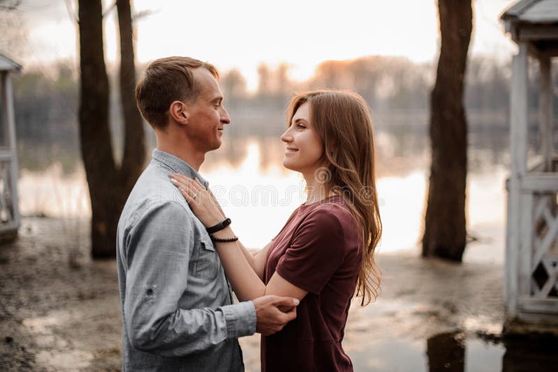 Paar die in liefde op elkaar letten ogen op de achtergrond van mooi meer royalty-vrije stock foto Paar die in liefde op elkaar letten ogen op de achtergrond van mooi meer royalty-vrije stock foto