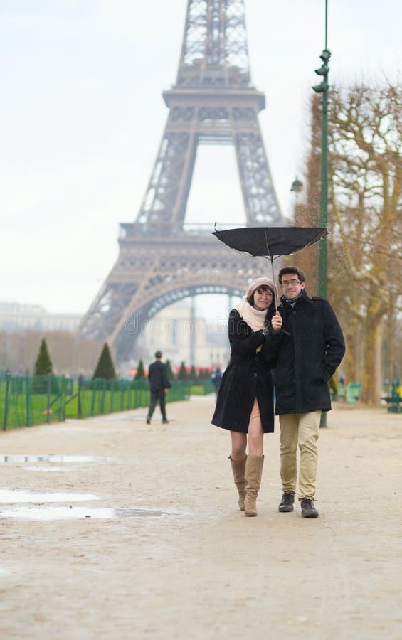 Paar die onder de regen met gebroken paraplu lopen royalty-vrije stock foto Paar die onder de regen met gebroken paraplu lopen royalty-vrije stock foto