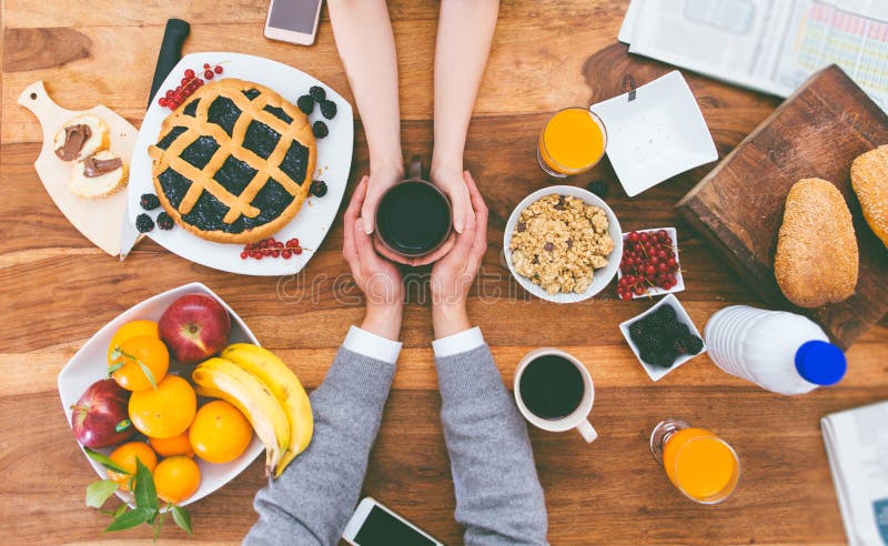 Couple having breakfast in the morning at home. Rich breakfast on the table and hot coffee. Couple having breakfast in the morning at home. Rich breakfast on the table and hot coffee