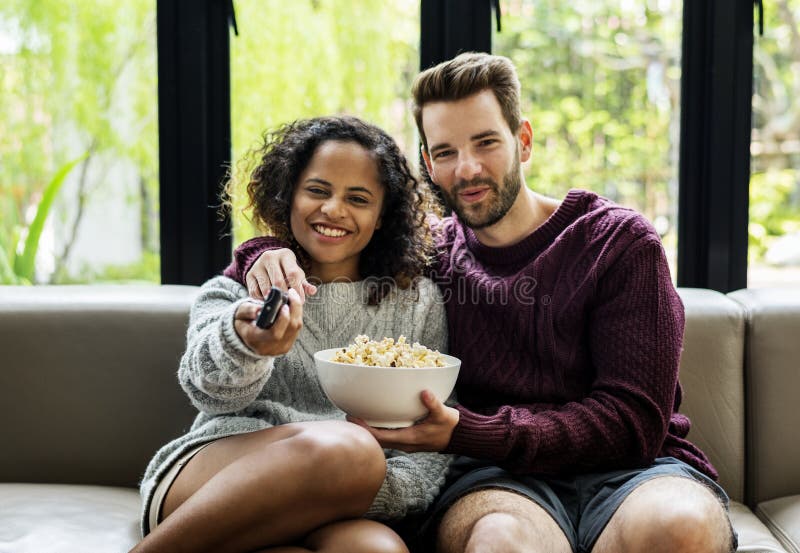Paar die op TV letten hebbend popcorn