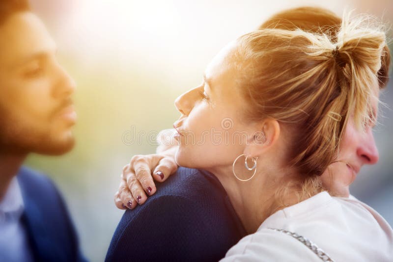 Paar die terwijl vrouw die een kus blazen aan de een andere mens koesteren royalty-vrije stock afbeelding Paar die terwijl vrouw die een kus blazen aan de een andere mens koesteren royalty-vrije stock afbeelding