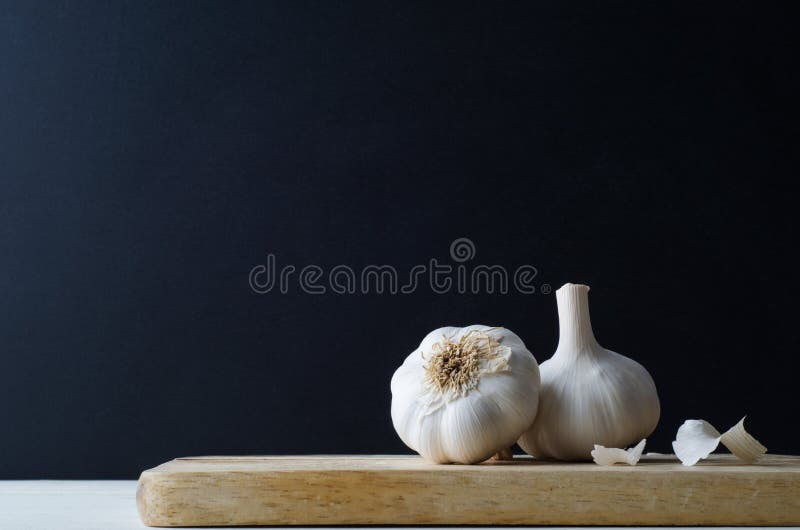 Paar Gehele Knoflookbollen met Verspreide Schillen op Houten Raad stock foto Paar Gehele Knoflookbollen met Verspreide Schillen op Houten Raad stock foto