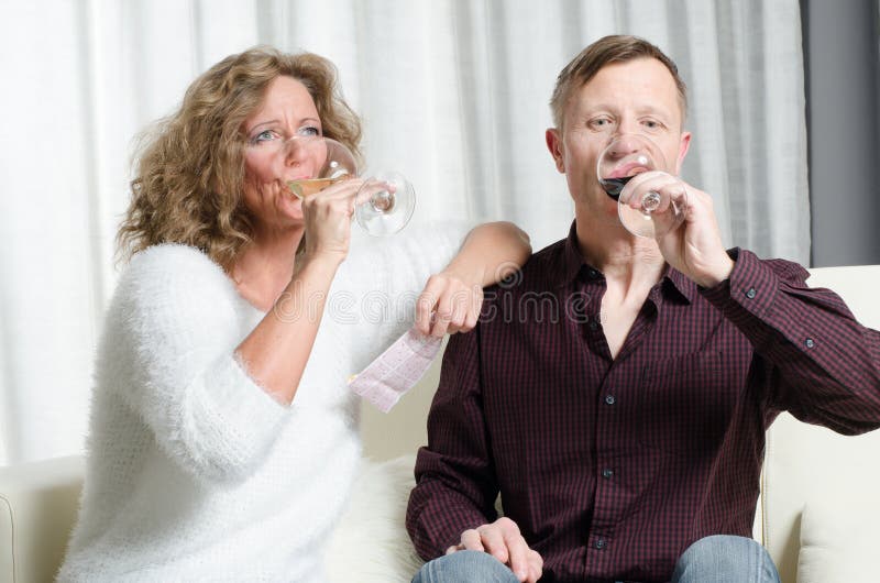 Paar ist Weinprobe auf Couch lizenzfreies stockfoto Paar ist Weinprobe auf Couch lizenzfreies stockfoto