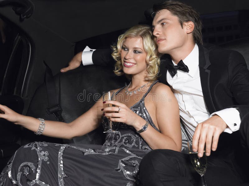 Paar met Champagne Flutes In Limousine stock afbeeldingen Paar met Champagne Flutes In Limousine stock afbeeldingen