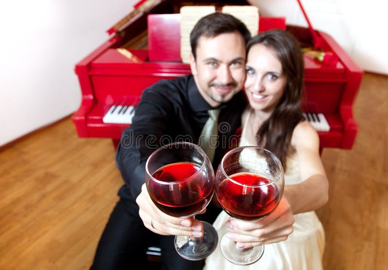 Paar met glazen wijn dichtbij piano stock fotografie Paar met glazen wijn dichtbij piano stock fotografie