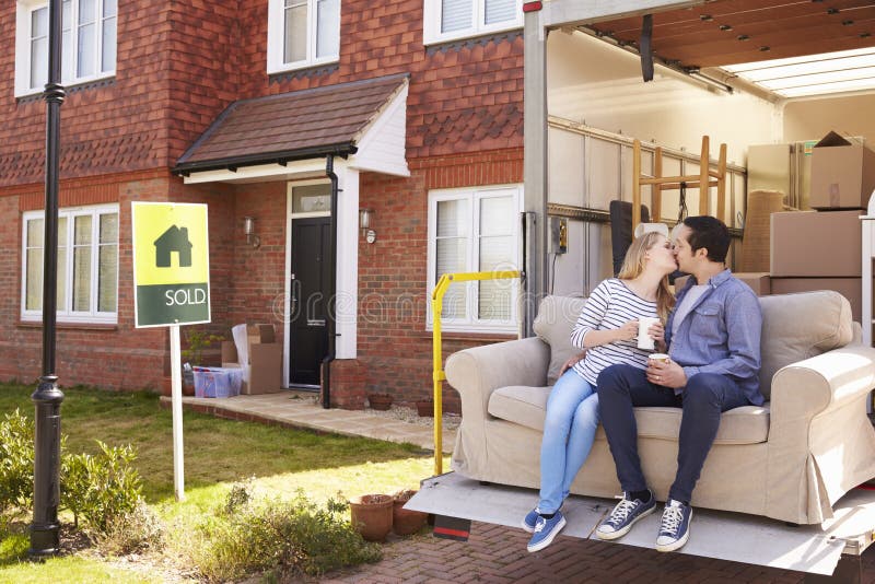 Paar met Sofa On Tail Lift Of-Verwijderingsvrachtwagen die zich naar huis bewegen stock fotografie Paar met Sofa On Tail Lift Of-Verwijderingsvrachtwagen die zich naar huis bewegen stock fotografie