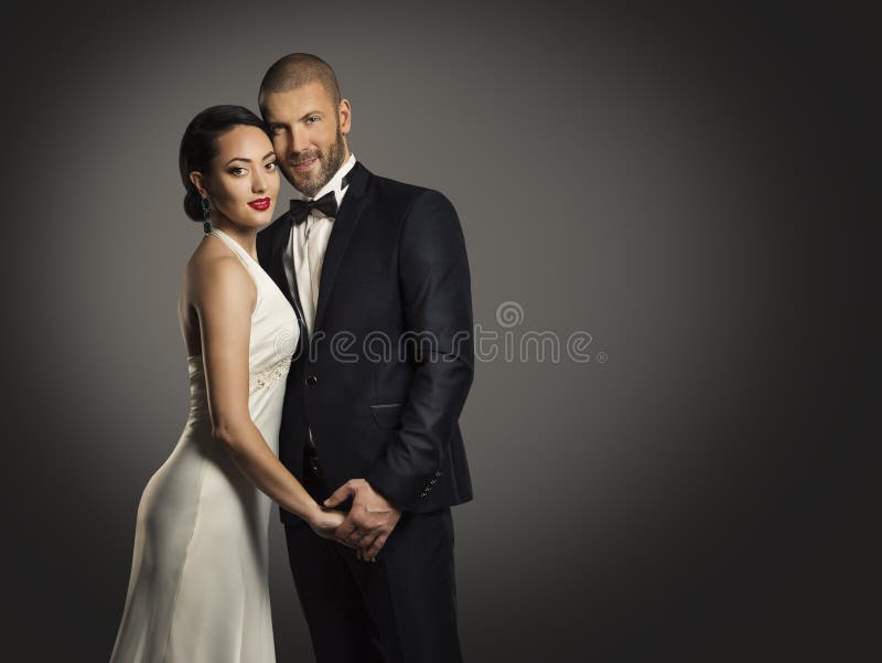 Couple Beauty Portrait, Handsome Man Well Dressed Black Suit and Elegant Beautiful Woman in White Dress, over black background. Couple Beauty Portrait, Handsome Man Well Dressed Black Suit and Elegant Beautiful Woman in White Dress, over black background