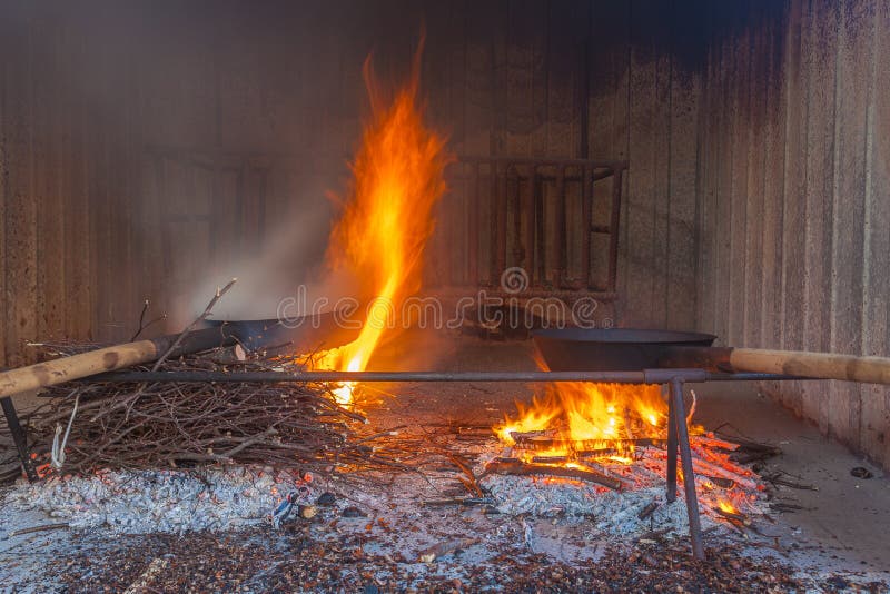 Paar traditionelle Pfannen zum Kochen von Kastanien über dem Feuer