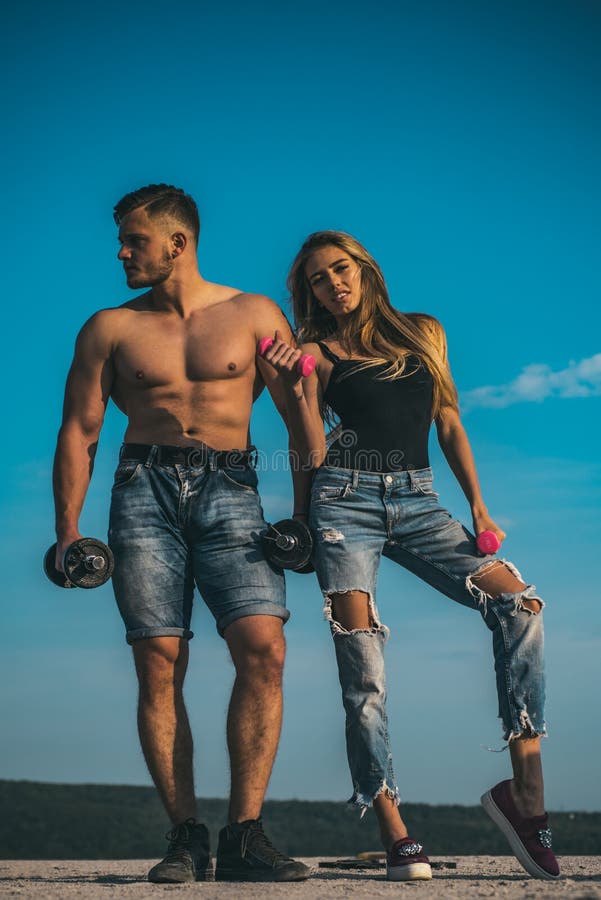 Paar van bodybuilders die omhoog spieren met domoren pompen , sportconcept Mens met spiertorso in denimborrels en stock fotografie Paar van bodybuilders die omhoog spieren met domoren pompen , sportconcept Mens met spiertorso in denimborrels en stock fotografie