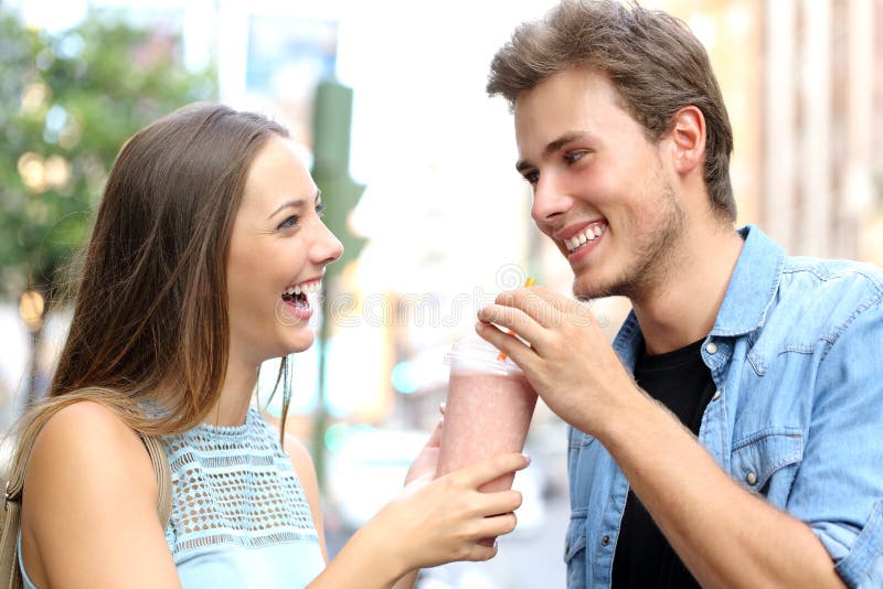 Paar of vrienden die een milkshake delen stock afbeeldingen Paar of vrienden die een milkshake delen stock afbeeldingen