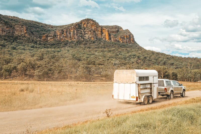Paardvlotter door vierwielige aandrijving langs een landweg in landelijk Australië wordt getrokken dat royalty-vrije stock afbeelding Paardvlotter door vierwielige aandrijving langs een landweg in landelijk Australië wordt getrokken dat royalty-vrije stock afbeelding