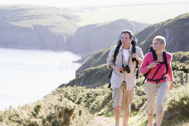 Paare auf dem draußen gehenden und lächelnden cliffside lizenzfreies stockbild Paare auf dem draußen gehenden und lächelnden cliffside lizenzfreies stockbild