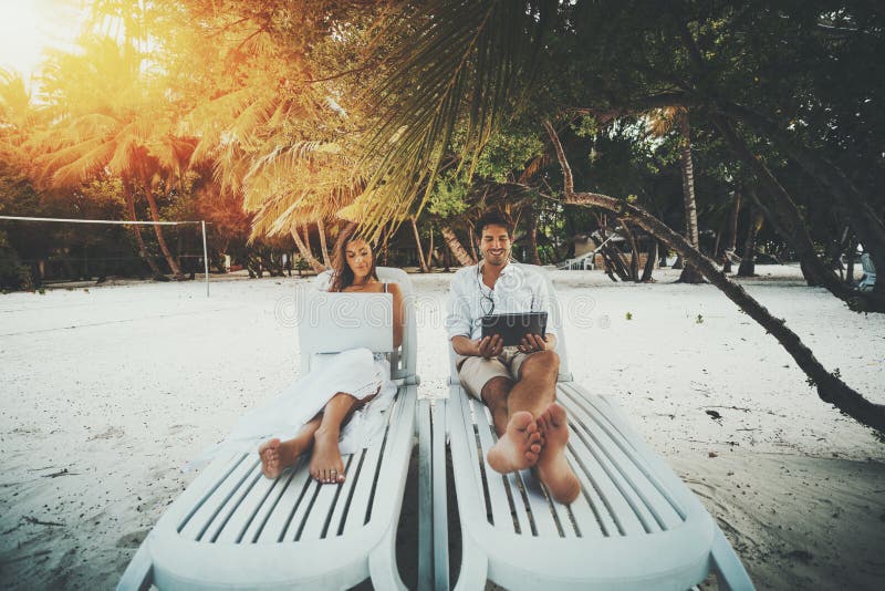Paare auf dem Strand mit ihren Geräten lizenzfreies stockbild Paare auf dem Strand mit ihren Geräten lizenzfreies stockbild